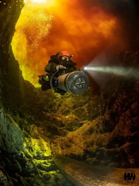 Photography by Marissa Eckert- A rebreather cave diver crosses through the tannic river water at the Devils Ear cave in Ginnie Springs, Florida